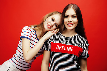 Image showing two best friends teenage girls together having fun, posing emotional on red background, besties happy smiling, lifestyle people concept