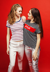 Image showing two best friends teenage girls together having fun, posing emotional on red background, besties happy smiling, lifestyle people concept