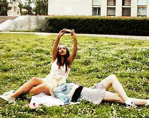 Image showing two young pretty teenager girls best friends laying on grass making selfie photo having fun, lifestyle happy people concept, students at summer