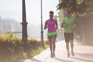 Image showing young multiethnic couple jogging in the city