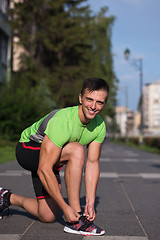 Image showing Young athlete, runner tie shoelaces in shoes