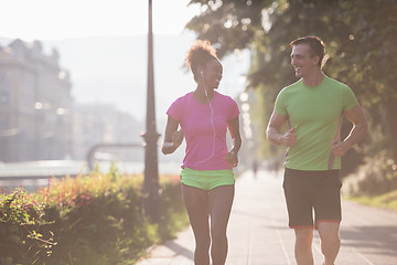 Image showing young multiethnic couple jogging in the city