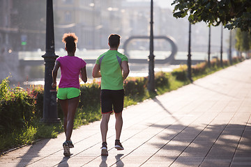 Image showing young multiethnic couple jogging in the city