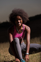 Image showing black woman runner tightening shoe lace