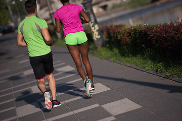 Image showing young smiling multiethnic couple jogging in the city