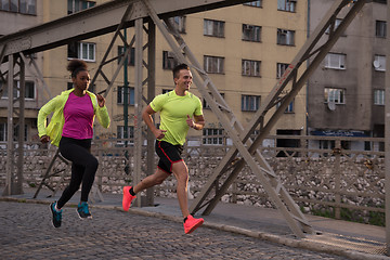 Image showing young multiethnic couple jogging in the city