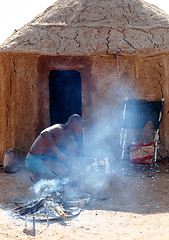 Image showing Himba man adjusts wooden souvenirs