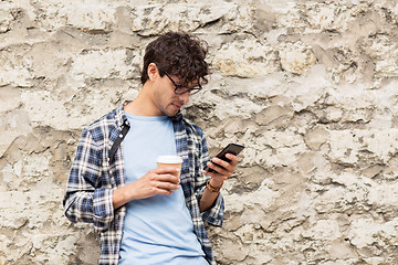 Image showing man with smartphone drinking coffee on city street