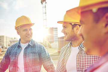 Image showing group of smiling builders in hardhats outdoors