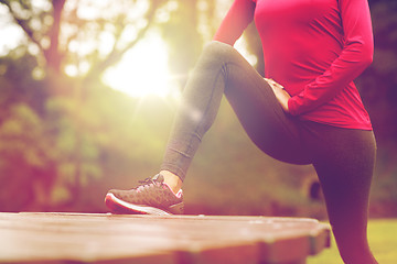 Image showing close up of woman stretching leg outdoors