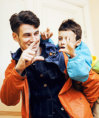 Image showing young handsome father with his son fooling around at home, lifestyle people concept