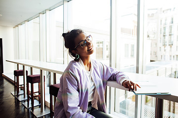 Image showing young cute hipster girl student sitting in cafe with notebook re