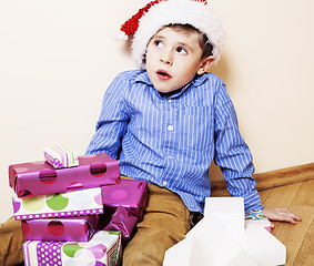 Image showing little cute boy with Christmas gifts at home. close up emotional