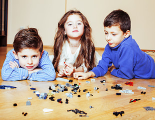 Image showing funny cute children playing lego at home, boys and girl smiling, first education role lifestyle