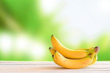 Image showing Yellow bananas on a wooden table