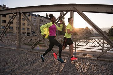 Image showing young multiethnic couple jogging in the city