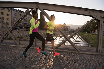 Image showing young multiethnic couple jogging in the city