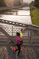 Image showing young multiethnic couple jogging in the city