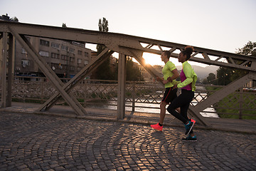 Image showing young multiethnic couple jogging in the city