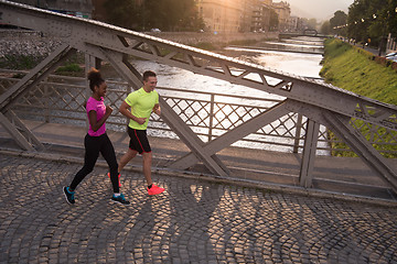 Image showing young multiethnic couple jogging in the city