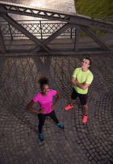 Image showing portrait of a young multiethnic couple jogging in the city