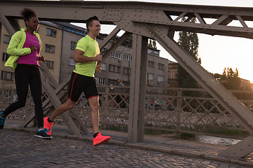 Image showing young multiethnic couple jogging in the city