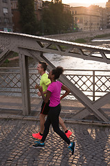 Image showing young multiethnic couple jogging in the city