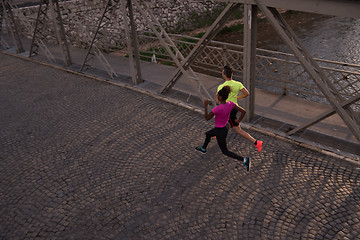 Image showing young multiethnic couple jogging in the city