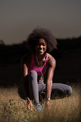 Image showing black woman runner tightening shoe lace