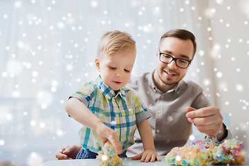 Image showing father and son playing with ball clay at home