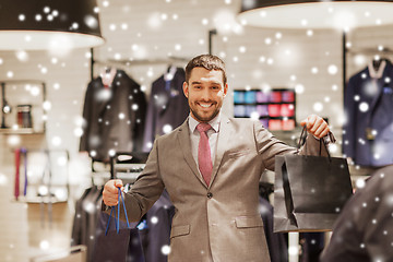 Image showing happy man with shopping bags at clothing store