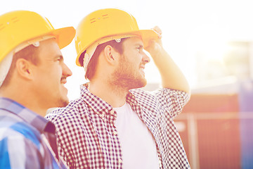 Image showing group of smiling builders in hardhats outdoors