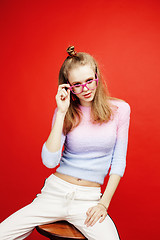 Image showing young pretty emitonal posing teenage girl on bright red background, happy smiling lifestyle people concept