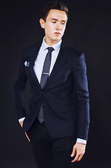 Image showing young pretty business man standing on black background, modern h