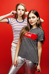 Image showing two best friends teenage girls together having fun, posing emotional on red background, besties happy smiling, lifestyle people concept