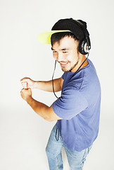 Image showing young asian man in hat and headphones listening music on white b