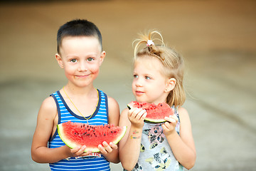 Image showing Young girl and boy eating watermelon