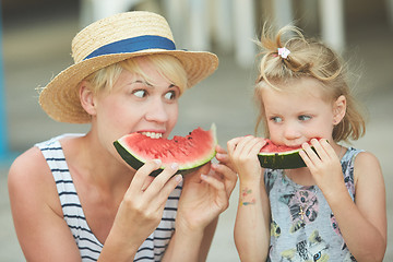 Image showing Mother And Daughter Enjoying Slices Of WaterMelon