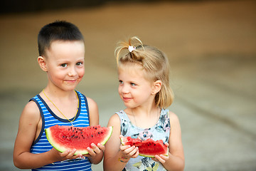 Image showing Young girl and boy eating watermelon