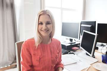 Image showing happy creative female office worker with computers