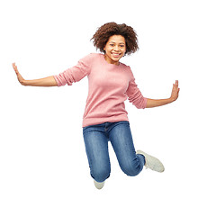 Image showing happy african american woman jumping over white