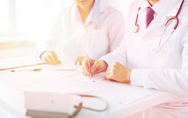 Image showing doctor and nurse writing prescription paper