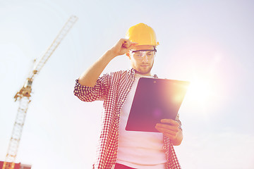 Image showing builder in hardhat with clipboard outdoors