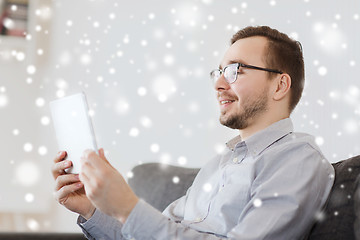 Image showing smiling man working with tablet pc at home