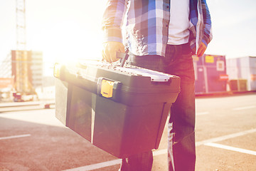 Image showing close up of builder carrying toolbox outdoors