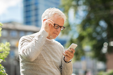 Image showing senior man texting message on smartphone in city