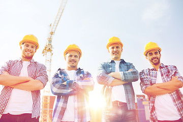 Image showing group of smiling builders in hardhats outdoors