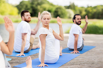 Image showing people making yoga in half lord of the fishes pose