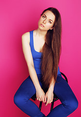 Image showing young happy slim girl with skipping rope on pink background smil