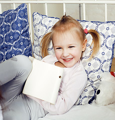 Image showing little cute girl laying in bed happy smiling, lifestyle people concept